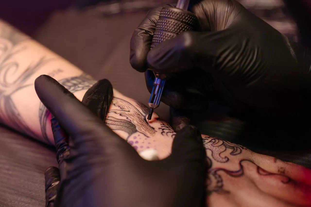 Tatuador haciendo uno de los estilos de tatuaje más habituales